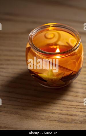 Bougie vanille éclairée dans un pot en verre. Foyer sélectif avec faible profondeur de champ. Banque D'Images