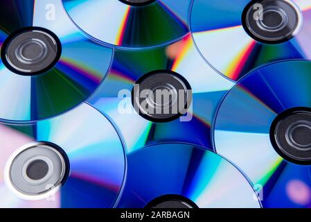 De nombreux disques compacts musicaux propres avec un spectre de couleurs arc-en-ciel comme fond lumineux Banque D'Images