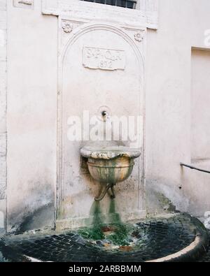 Rome, Italie - 31 décembre 2019 : petite fontaine à boire et décoration en pierre, Rome, Italie. Banque D'Images