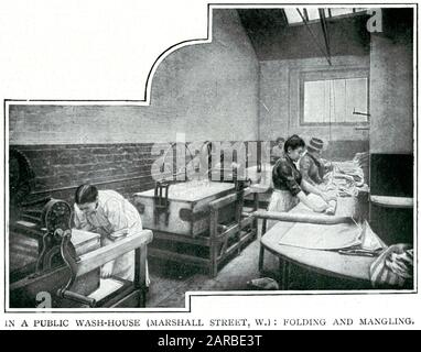 Intérieur d'un lavoir public avec des femmes essorant des vêtements mouillés sur des mangles et les pliant. Banque D'Images