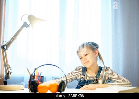 Image photoespacée d'une jeune fille étudiant quelque chose en utilisant l'ordinateur à la maison Banque D'Images