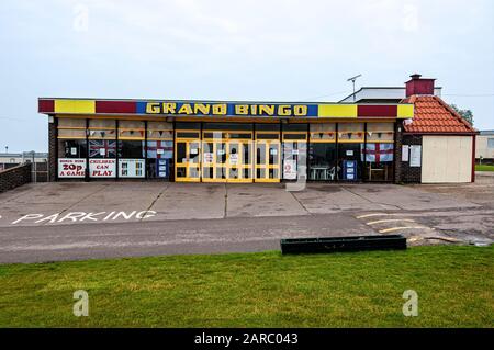 Une grande salle rectangulaire de bingo pour le divertissement familial a de nombreux avis collés à travers ses fenêtres et portes avec un parking en béton devant Banque D'Images