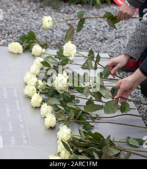 Weimar, Allemagne. 27 janvier 2020. Des fleurs commémorant les victimes du socialisme national sont placées sur la plaque métallique du Mémorial de Buchenwald. Les noms de plus de 50 nations d'où sont venus les victimes sont gravés par ordre alphabétique dans la section du milieu. Crédit: Michael Reichel/Dpa/Alay Live News Banque D'Images