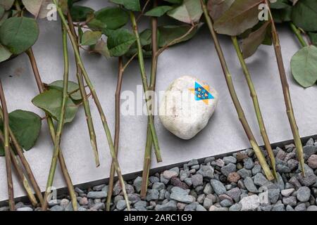 Weimar, Allemagne. 27 janvier 2020. Une pierre à l'étoile de David et des fleurs commémorant les victimes du socialisme national sont placées sur la plaque métallique du Mémorial de Buchenwald. Les noms de plus de 50 nations d'où sont venus les victimes sont gravés par ordre alphabétique dans la partie centrale de la plaque. Crédit: Michael Reichel/Dpa/Alay Live News Banque D'Images