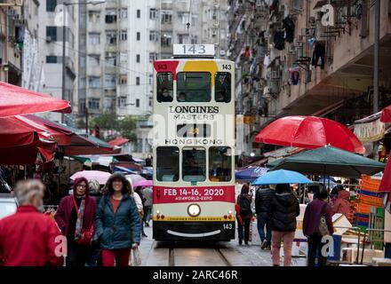 Hong Kong, Chine : 27 Janvier 2020. Un tramway de Hong Kong traverse la foule du marché de la rue Chun Yeung sur la route jusqu'au terminus. Le tram Banque D'Images