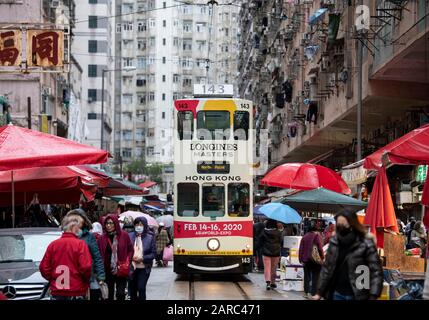 Hong Kong, Chine : 27 Janvier 2020. Un tramway de Hong Kong traverse la foule du marché de la rue Chun Yeung sur la route jusqu'au terminus. Le tram Banque D'Images