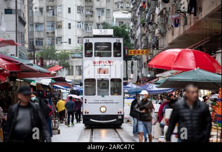 Hong Kong, Chine : 27 Janvier 2020. Un tramway de Hong Kong traverse la foule du marché de la rue Chun Yeung sur la route jusqu'au terminus. Le tram Banque D'Images