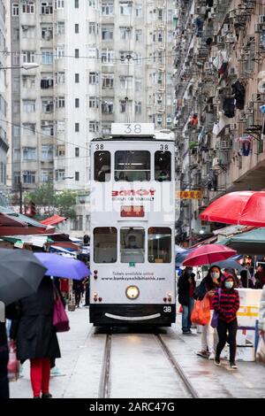 Hong Kong, Chine : 27 Janvier 2020. Un tramway de Hong Kong traverse la foule du marché de la rue Chun Yeung sur la route jusqu'au terminus. Le tram Banque D'Images