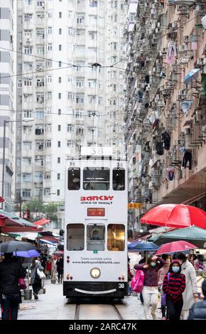 Hong Kong, Chine : 27 Janvier 2020. Un tramway de Hong Kong traverse la foule du marché de la rue Chun Yeung sur la route jusqu'au terminus. Le tram Banque D'Images