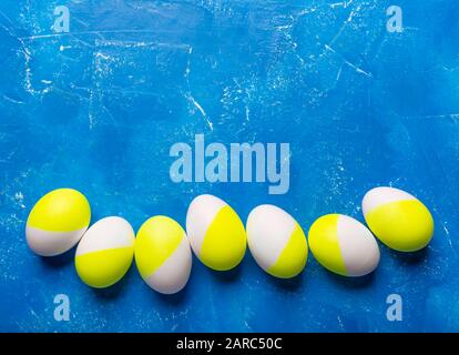 Cinq oeufs peints à pâques jaune vert sur bleu Banque D'Images