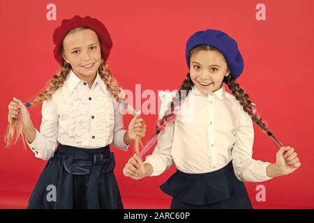 L'École de l'amitié. Sur la même vague. Usure uniforme de l'école formelle écolières. Les enfants belles filles de long cheveux tressés. Style de fantaisie. Peu de filles avec des tresses, des prêts pour l'école. Concept de la mode de l'école. Banque D'Images