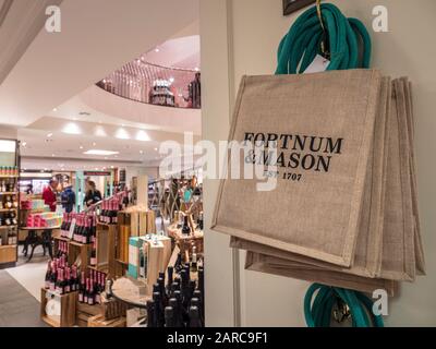 Intérieur Fortnum & Mason intérieur de la salle de restauration avec exposition luxueuse de boissons, vins et boissons alcoolisées. Sacs à provisions en tissu de marque Fortnum et Mason affichés en premier plan pour les clients. Fortnum & Mason Food & Drink Hall Store Piccadilly St. James's, Londres W1A 1ER Banque D'Images