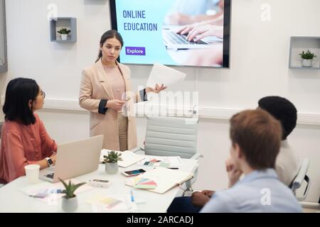 Portrait de la jeune femme d'affaires donnant une présentation sur l'éducation en ligne au groupe d'étudiants dans la salle de conférence universitaire, espace de copie Banque D'Images