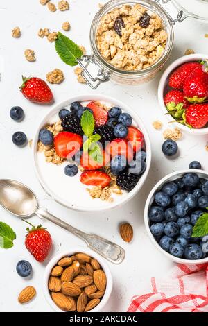 Granola yogourt grec avec les baies fraîches sur tableau blanc. Banque D'Images