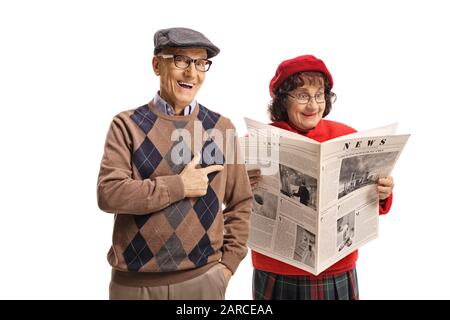 Homme âgé riant et se moquant d'une femme lisant un journal isolé sur fond blanc Banque D'Images