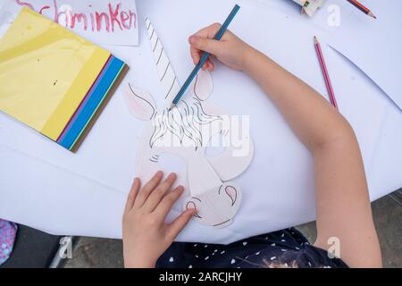 un petit enfant peint une image avec des crayons. Banque D'Images