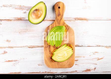 Toasts de patate douce avec avocat sur planche en bois. Concept de repas sain. Cuisine propre, cuisine végétarienne, vue sur le dessus Banque D'Images