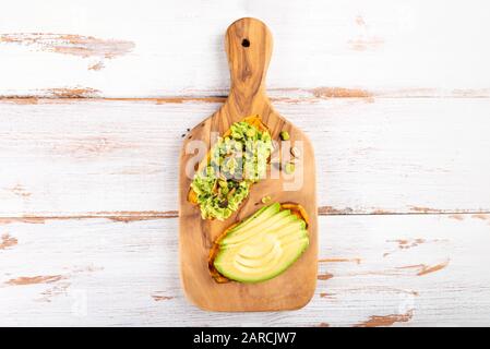 Toasts de patate douce avec avocat et graines de tournesol sur planche en bois. Concept de repas sain. Cuisine propre, cuisine végétarienne, vue sur le dessus Banque D'Images