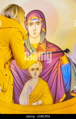 La femme peint une murale dans la célèbre cathédrale de l'Ascension, alias la cathédrale de Zenkov, à Almaty Kazakhstan Banque D'Images