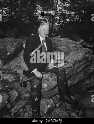 Le président américain Herbert Hoover - portant une cravate de costume et une fédora - pêche à la mouche dans un petit ruisseau en 1936. Banque D'Images