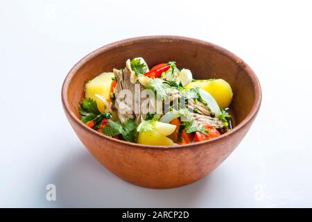 Hachlama dans une plaque d'argile. Ingrédients: Côtes de boeuf, pommes de terre, herbes, ail. Sur fond blanc Banque D'Images