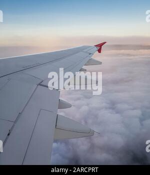 Avion Commercial Wing Shot Survolant Le Magnifique Lever Du Soleil Banque D'Images