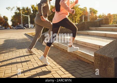 Un homme et une femme sont en marche le long de la rue de la ville dans la matinée. Banque D'Images