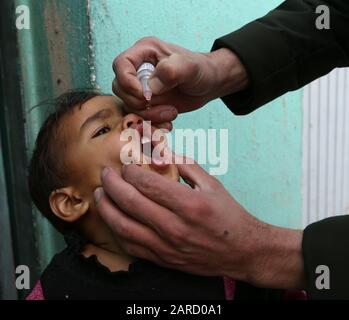 (200127) -- GHAZNI (AFGHANISTAN), 27 janvier 2020 (Xinhua) -- un agent de santé donne la dose de vaccination contre la poliomyélite à un enfant lors d'une campagne de vaccination dans la province de Ghazni, en Afghanistan, le 27 janvier 2020. Le Ministère afghan de la santé publique a lancé lundi une campagne nationale visant à administrer la dose de vaccination contre la poliomyélite à 9,1 millions d'enfants de moins de cinq ans, a déclaré le ministère dans une déclaration. (Photo De Sayed Mominzadah/Xinhua) Banque D'Images