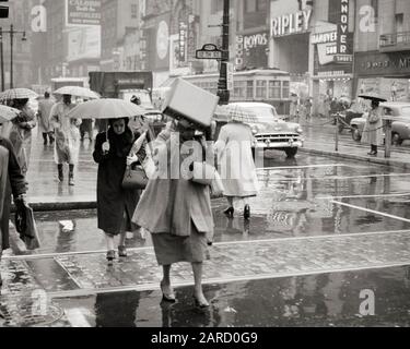 ANNÉES 1950 PIÉTONS FEMME TENANT LA BOÎTE SUR LA TÊTE PRIS DANS LA TEMPÊTE SOUDAINE DE PLUIE 12ÈME & RUE DU MARCHÉ PHILADELPHIE PENNSYLVANIE USA - C664 HARS FOULES FEMMES COPIE ESPACE FEMMES PLEINE LONGUEUR FEMMES PLUVIEUX PERSONNES BOUTIQUES AUTOMOBILE HOMMES PLEURANT PIÉTONS TRANSPORT B&W COLLECTE ACHETEURS PROTECTION RUES AUTOS PA PRIS MAGASINS TROLLEY AUTOMOBILES VILLES EVADEZ LES VÉHICULES SOLUTIONS DE COOPÉRATION COMMERCIALE LES ENTREPRISES NOIR ET BLANC LA VILLE D'AMOUR FRATERNEL HAR001 À L'ANCIENNE SOUDAIN Banque D'Images