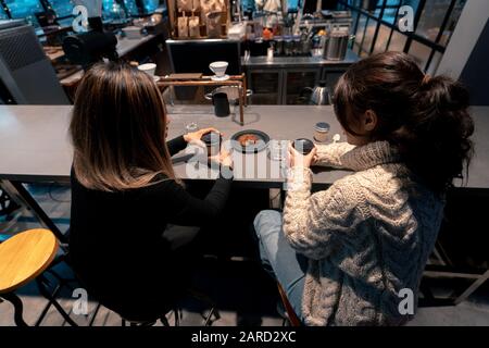 Vue Arrière Sur Le Café De Style Caucasien Et Asiatique Pour Les Jeunes Femmes. Concept D'Amitié Interraciale. Banque D'Images