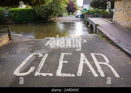 Il est clair que les conducteurs de la rivière Winddrush à Bourton-on-the-Water dans la Co anglaise ne doutent pas que c'est l'approche d'une ford qui traverse la rivière peu profonde Winddrush Banque D'Images