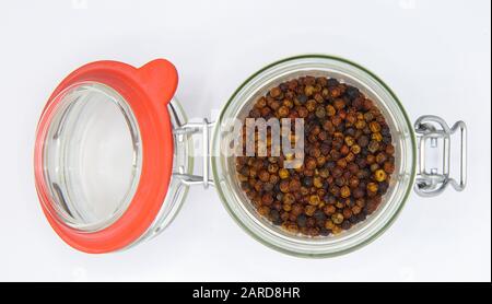 Vue de dessus sur l'ouverture d'un pot en verre à conservation isolée avec anneau en caoutchouc rouge et cornes de poivre mélangé, fond blanc blanc blanc Banque D'Images