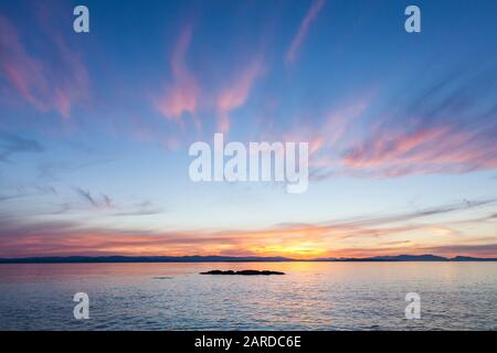 Coucher de soleil sur l'île de Vancouver et le détroit d'Haro vu du parc County sur l'île San Juan, Washington, États-Unis. Banque D'Images