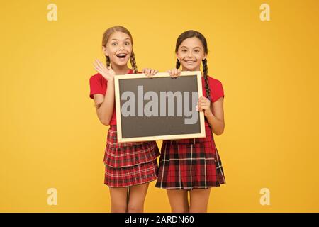 Équipe de l'initiative de camarades. Inscrivez-vous le club scolaire. Les élèves de la communauté. Cours de Cheerleading. L'annexe de l'école. School girls cute pupils uniforme rouge tenir copie tableau noir l'espace. Annonce école concept. Banque D'Images