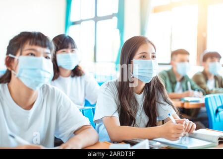 Les élèves portent un masque de protection pour éviter les germes, les virus et les particules 2,5 microns en classe Banque D'Images
