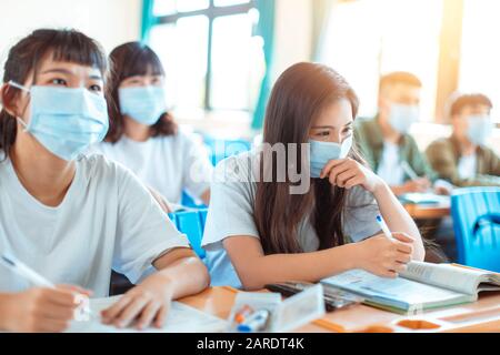 Les élèves portent un masque de protection pour éviter les germes, les virus et les particules 2,5 microns en classe Banque D'Images