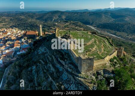 Vue aérienne du château de Cervera del Maestre avec des vestiges de construction intérieure excavés en ruines entourés d'un mur extérieur partiellement restauré d'origine arabe Banque D'Images