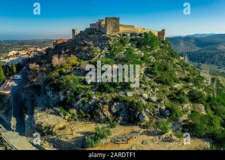 Vue aérienne du château de Cervera del Maestre avec des vestiges de construction intérieure excavés en ruines entourés d'un mur extérieur partiellement restauré d'origine arabe Banque D'Images