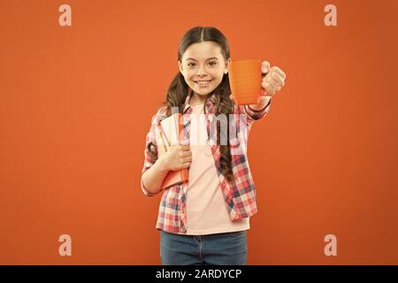 La littérature pour enfants. Aime passer du temps à la maison. Cacao chaud et bon livre idéal pour soirée agréable. Lecture bucket list. Dépenser temps agréable avec livre préféré. Fille tenir une tasse de thé et d'adresses. Banque D'Images