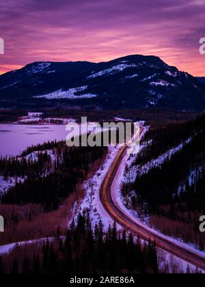 Lever du soleil, route courbe, ciel rose, Rocheuses canadiennes, Alberta, Canada. Banque D'Images