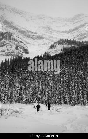 Deux Skieurs De Campagne Entourés De Montagnes Banque D'Images