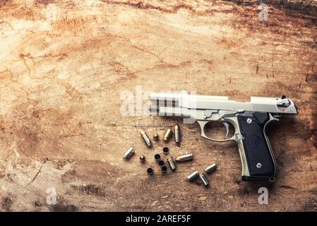 balles de pistolet de 9 mm et magazine parsemés sur le fond en bois vue de dessus - style vintage film grain filtre effet de styles Banque D'Images
