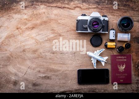 Concept de voyage sur table en bois avec caméra de film.vue de dessus des accessoires d'été de plage avec espace de copie, passeport de Thaïlande, vêtements. Banque D'Images