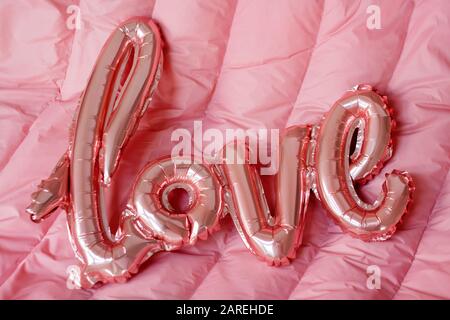 Mot d'amour du ballon gonflable rose sur fond rose. Le concept de romance, Saint Valentin. J'adore le ballon en feuille d'or rose Banque D'Images