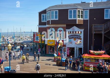 Une foule de visiteurs et de touristes près de la boutique de glace de Dreyer et du stand de hot dog de Nathan au Pier 39 à San Francisco, Californie, une journée ensoleillée. Banque D'Images