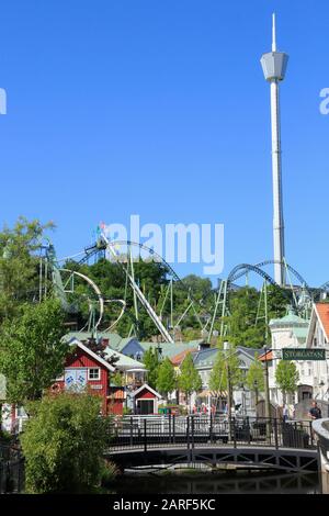 Vue sur Storgatan, les pistes de montagnes russes et la grande tour de l'attraction Atmosspeur dans le parc à thème Liseberg de la ville de Göteborg, en Suède. Banque D'Images