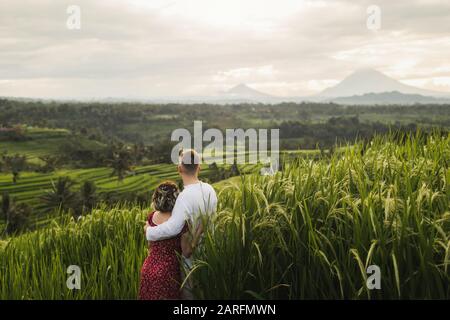 Voyage À Bali, Indonésie. Couple voyageurs regardant les célèbres terrasses de riz Jatiluwih et le volcan Agung le matin. Concept Wanderlust Banque D'Images