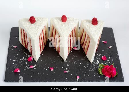 Un beau gâteau sur un stand dans un restaurant sur un fond blanc. Trois portions égales de tarte délicieuse et douce Banque D'Images