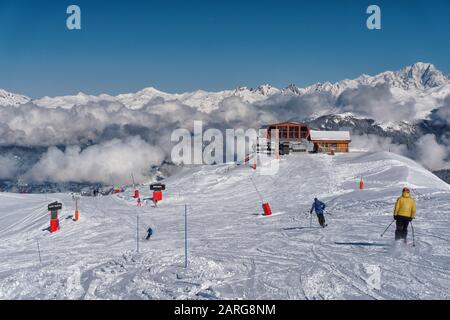 Les skieurs sur les pistes au-dessus de Meribel dans les alpes françaises atteignent un choix de continuer vers Meribel, ou tourner à gauche vers St Martin de Belleville Banque D'Images