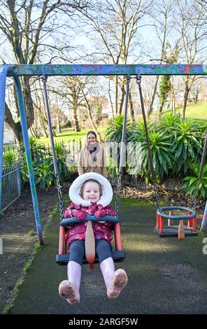 Brighton Royaume-Uni 28 janvier 2020 - 3 ans Isabella aime une promenade sur les balançoires dans le Queens Park Brighton avec sa mère poussant sur une belle journée ensoleillée mais froide en Grande-Bretagne . Crédit: Simon Dack / Alay Live News Banque D'Images